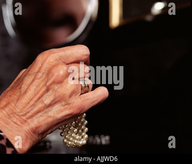 Close up of a senior woman holding a pearl bracelet Banque D'Images