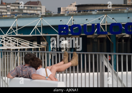 Jeune couple vous détendre dans chaque bras avec les pieds sur le pont du ferry au départ de Boulogne sur Mer Pas de Calais Banque D'Images