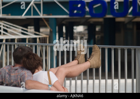 Jeune couple vous détendre dans chaque bras avec les pieds sur le pont du ferry au départ de Boulogne sur Mer Pas de Calais Banque D'Images