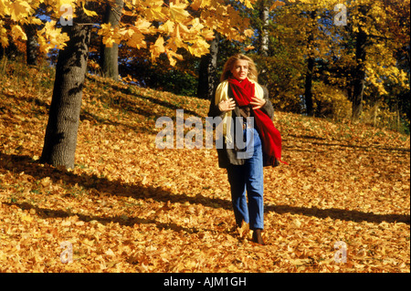 Belle blonde marche à travers champ de feuilles mortes en Suède Banque D'Images