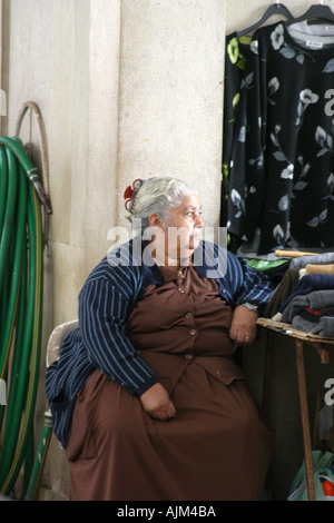 Vieille Femme vente de vêtements au marché local Silves Algarve Portugal Banque D'Images