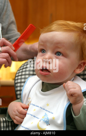 Un Bebe Ayant Sa Premiere Coupe De Cheveux Ages De 1 Ans Un Bebe Est La Lutte Contre La Coiffure Et S Indigner Photo Stock Alamy