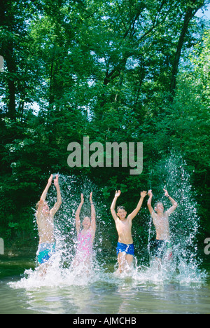 Les enfants s'éclabousser dans un étang Banque D'Images