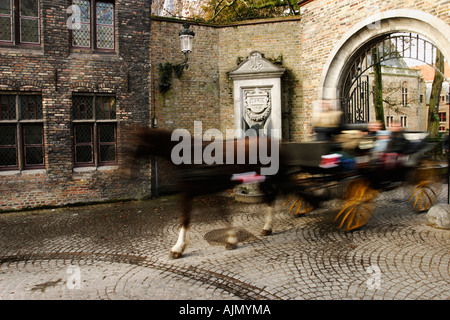 Les touristes voyager dans un cheval et un chariot à Noël. La place du marché, Bruges, Belgique. Banque D'Images