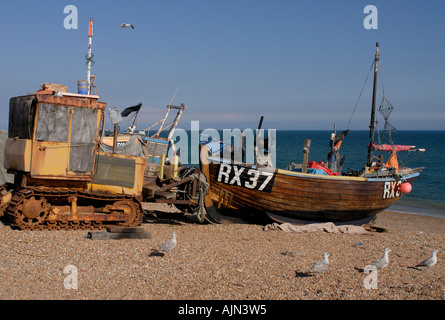 Old fashioned clinker traditionnel bateau de pêche construit avec une toile voile tiré vers le haut sur la plage à Hastings Banque D'Images