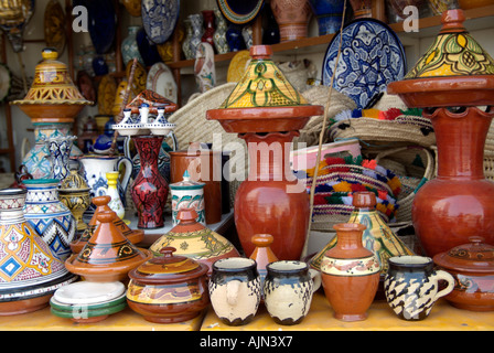 Une échoppe de marché débordant de pots de céramique peint de couleurs vives et de tagines et chapeaux de paille à Tanger, Maroc Banque D'Images