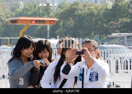 La place Tiananmen : quatre jeunes femmes de prendre des photos de touristes chinois Banque D'Images