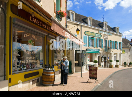 L'achat de vin en France Femme visiteur parcourt les bouteilles sur l'extérieur de l'écran 'Boutique vin Cave des Vieilles Vignes',à Meursault village, Bourgogne France Banque D'Images