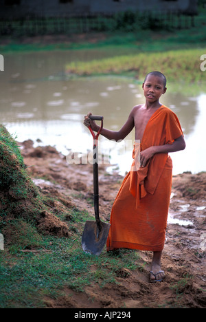 Robe safran moine novice qui travaillent dans les champs à côté du monastère près de la groupe Roulos près de Angkor Wat Siem Reap Cambodge Banque D'Images