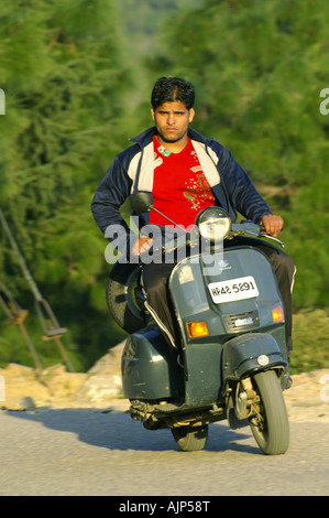 Jeune garçon indien man riding bike moto scooter à l'extérieur. Banque D'Images