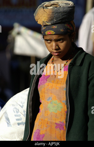 Les femmes indiennes en saris colorés transportant une charge lourde de gravier sur la tête d'efforts at construction site, les constructeurs de l'Inde Banque D'Images