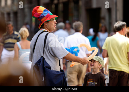 Un homme habillé en clown donne un ballon à un enfant modélisées à Palma de Majorque, en Espagne, le mardi, 17 juillet 2007 . Banque D'Images