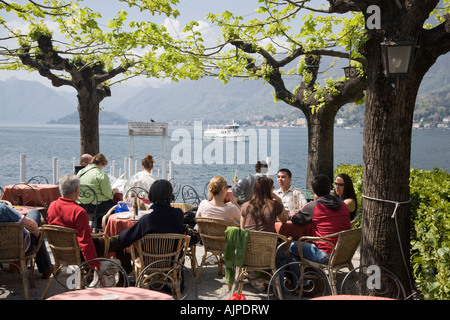 Les gens assis à la terrasse d'un café à Bellagio, Lac de Côme, Lombardie, Italie Banque D'Images