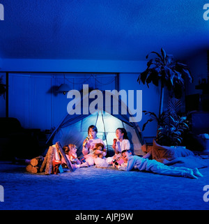 Enfants jouant sous une tente dans le salon Banque D'Images