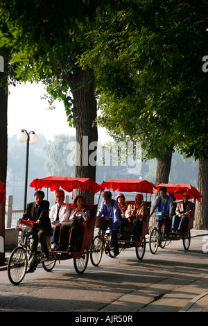 Les conducteurs de pousse-pousse en tenant sur une tournée touristique dans la région des lacs Houhai Beijing Chine Banque D'Images