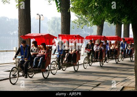 Les conducteurs de pousse-pousse en tenant sur une tournée touristique dans la région des lacs Houhai Beijing Chine Banque D'Images