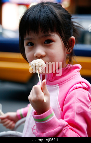 Young Girl eating au Zhenwumiao Road 1 nuit food market près de Wangfuging Dajie Beijing Chine Banque D'Images