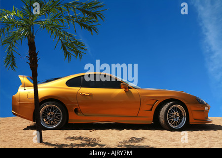 Voiture sport jaune orange sur le sable d'Or, dans Palm belle vie Banque D'Images