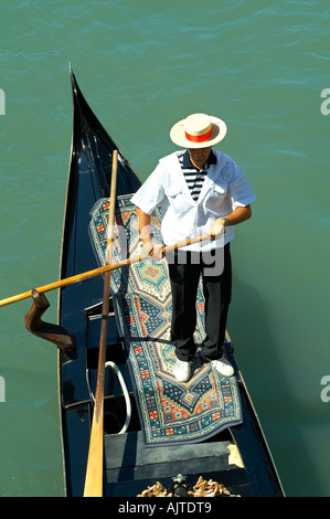 Gondolier dans une gondole portant un chapeau de paille Banque D'Images