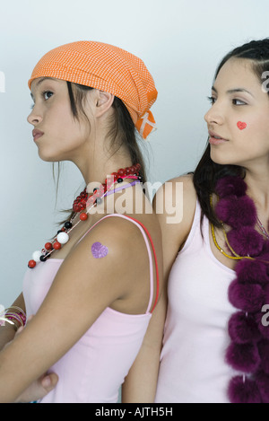 Deux jeunes femmes, l'un d'amis de se retourner vers l'autre, faisant la moue, à la taille, portrait Banque D'Images