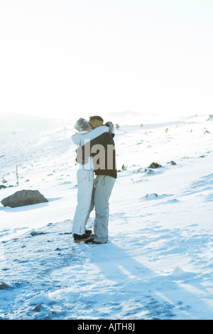 Père et fille debout sur une piste de ski, hugging Banque D'Images