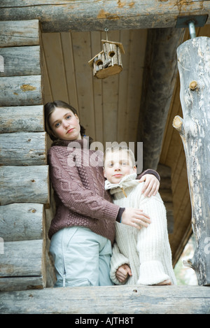 Teen girl embracing petit frère, portrait Banque D'Images