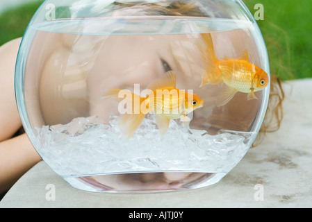 Little girl peeking through Goldfish Bowl, close-up Banque D'Images