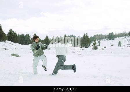 Deux jeunes amis bousculades dans la neige, pleine longueur Banque D'Images