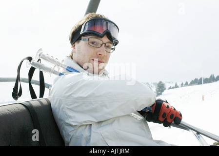 Jeune homme ski skieur en tenant Banque D'Images