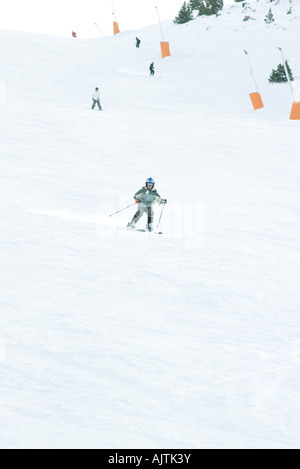 Jeune skieur sur une piste de ski, pleine longueur, dans la distance Banque D'Images