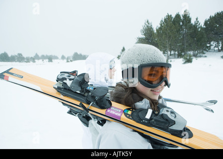 Deux jeunes skieurs à marcher ensemble, à l'exercice skis sur les épaules Banque D'Images