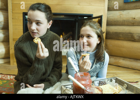 Adolescentes ayant snack par cheminée Banque D'Images