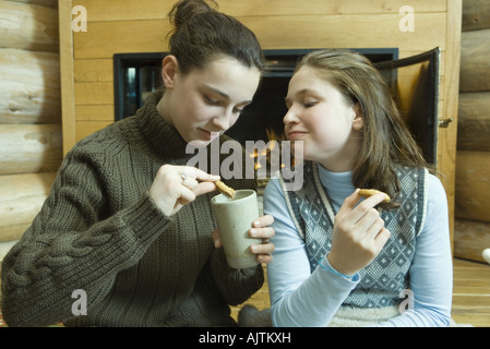 Adolescentes ayant snack par cheminée Banque D'Images