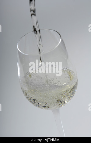 Verre de vin blanc est versé Banque D'Images