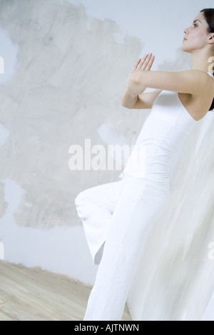 Femme debout dans la posture de l'arbre, side view Banque D'Images