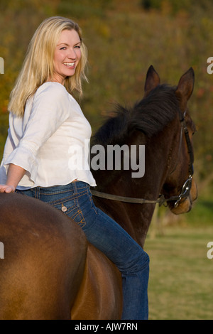 Une jolie jeune femme montant un cheval bareback au cours de l'automne Banque D'Images