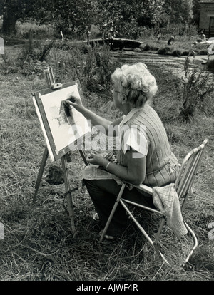 1970 noir et blanc femme de candide (60s) en train de dessiner des Cotswolds, UK, 1980. Banque D'Images