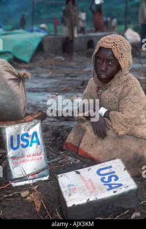 L'alimentation de l'enfant de réfugiés rwandais parmi nous attend de l'aide alimentaire dans le camp de réfugiés de l'ONU conteneurs. Banque D'Images