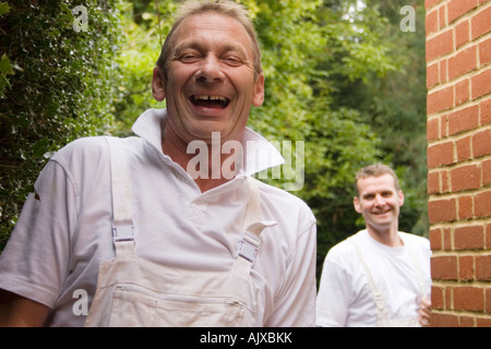 Portrait deux ouvriers heureux portant des combinaisons blanches Banque D'Images