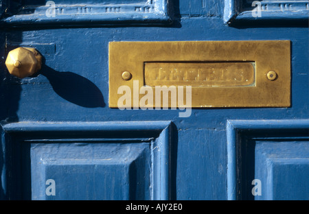 Boîte aux lettres en laiton et poignée de porte à panneaux bleu Banque D'Images