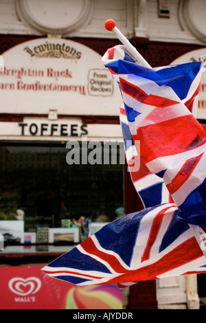 Drapeaux de l'Angleterre en plastique dans le vent à l'extérieur de vieux sweet shop à l'entrée de l'ancienne jetée ouest sur le front de mer de Brighton, Angleterre, RU Banque D'Images