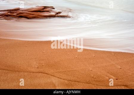 Plage de sable et rochers rouges avec du surf et schémas d'écoulement, Campbell's Cove, PE/Île-du-Prince Edward Island, Canada Banque D'Images