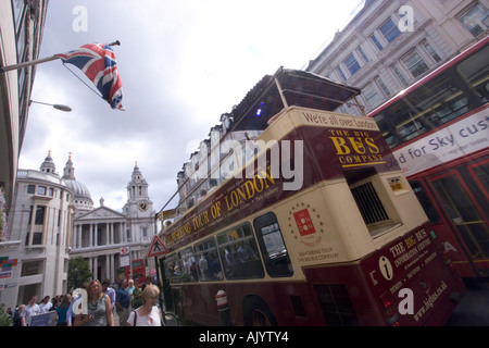 Visite à toit ouvert du bus touristique londonien avec drapeau union Jack flottant sur la façade du magasin Banque D'Images