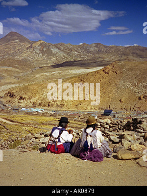 Paire d'amis femmes autochtones dans des vêtements traditionnels siègent au bord de la falaise par les mines Potosi Bolivie Amérique Latine du Sud Banque D'Images