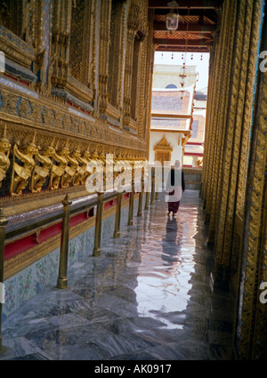 Femme marche à travers de somptueuses décorées golden temple extérieur long couloirs Wat Phra Kaew Bangkok Thailande Asie du sud-est Banque D'Images