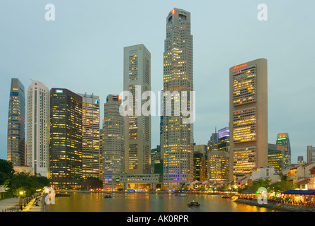 Un crépuscule sur la rivière Singapour avec des restaurants sur Boat Quay et tours de bureaux autour de la Place Raffles Singapore Banque D'Images