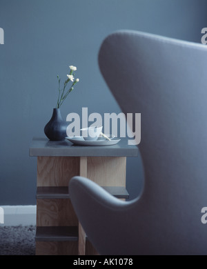Vue rapprochée de l'arrière de couleur bleu-gris Arne Jacobsen fauteuil 'Swan' en bleu moderne salon avec étagères en bois gris table basse Banque D'Images