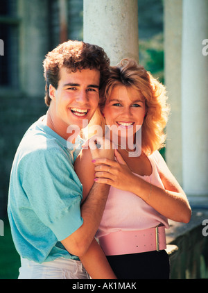 Portrait of happy young couple outdoors par colonnes de bâtiment. Banque D'Images