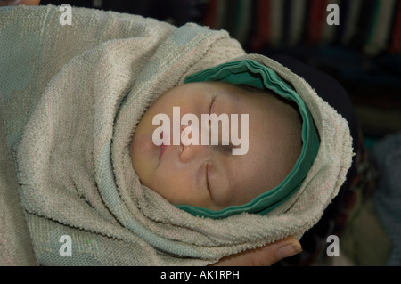 Bébé endormi en couverture sur un trajet en bus au Laos Banque D'Images