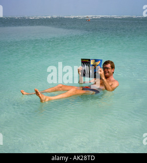 Un homme seul en bref les slips et lunettes flottant et la lecture d'un magazine sur la mer Morte Israël Banque D'Images